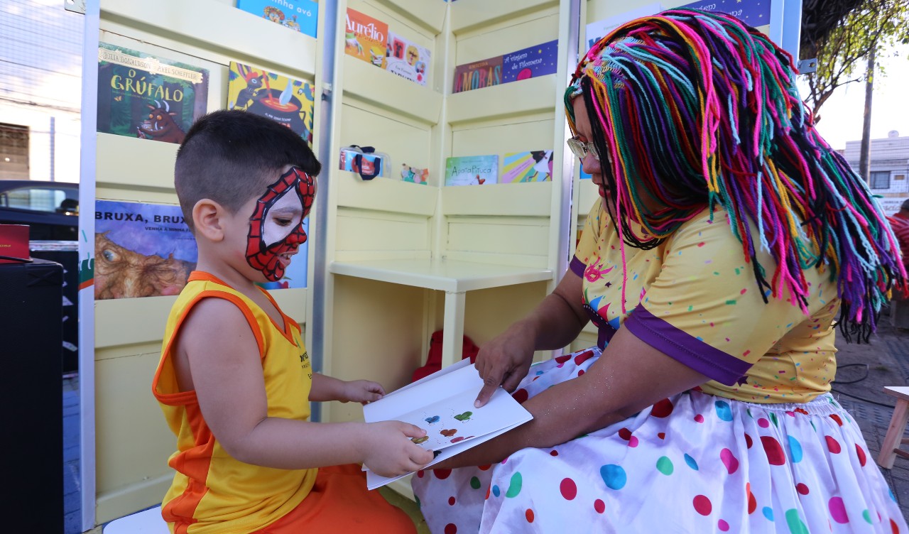 educadora social lê um livro com uma criança